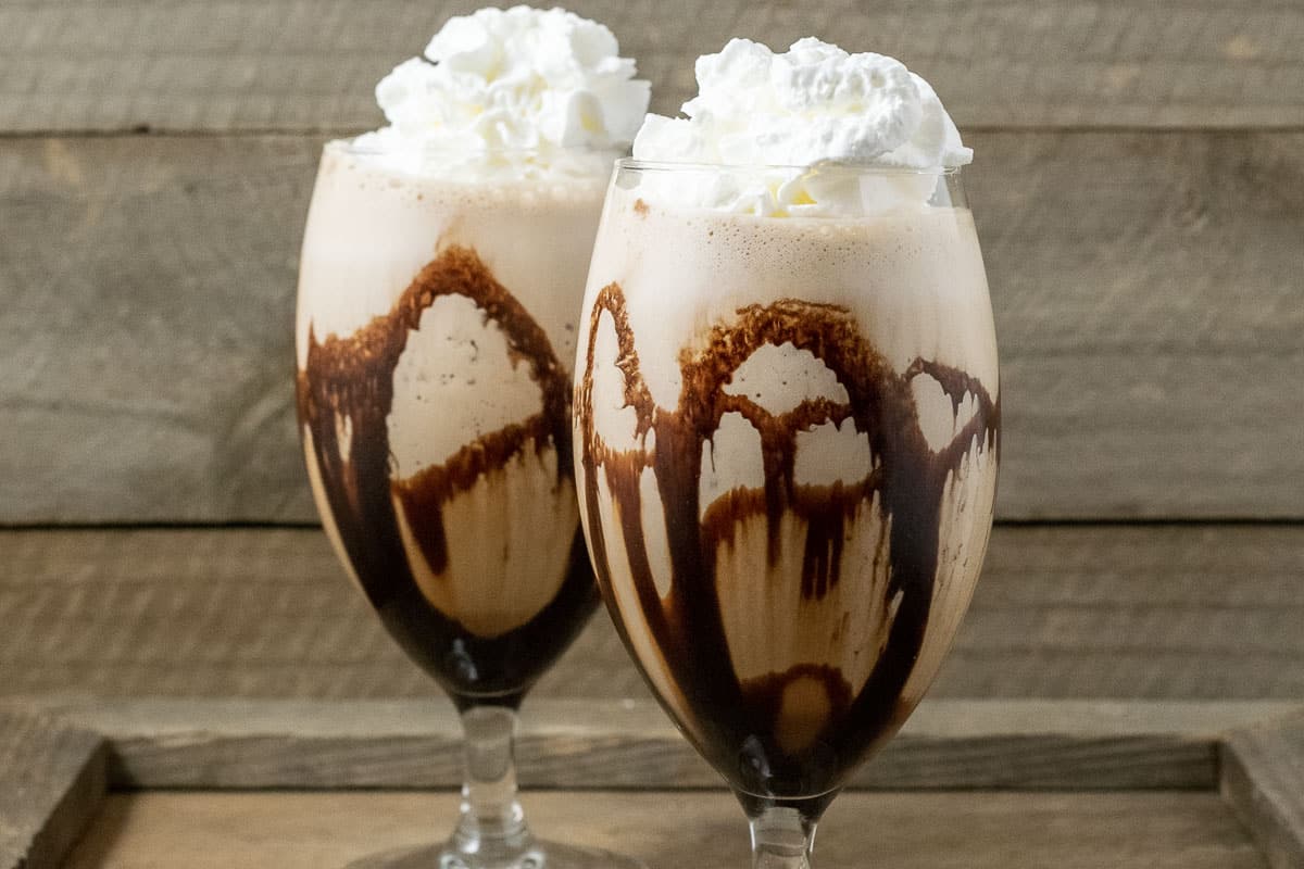 two Banana Mocha Frappe drinks topped with whipped cream.