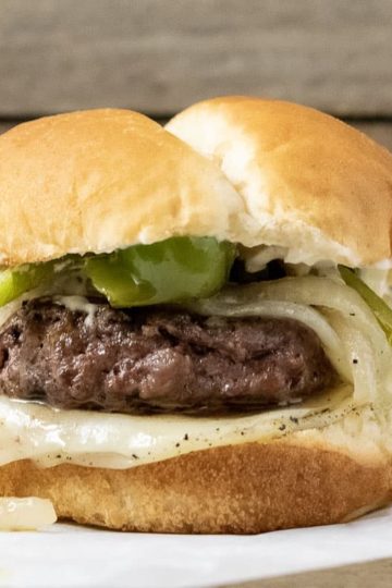 a close up front view of a philly cheesesteak burger