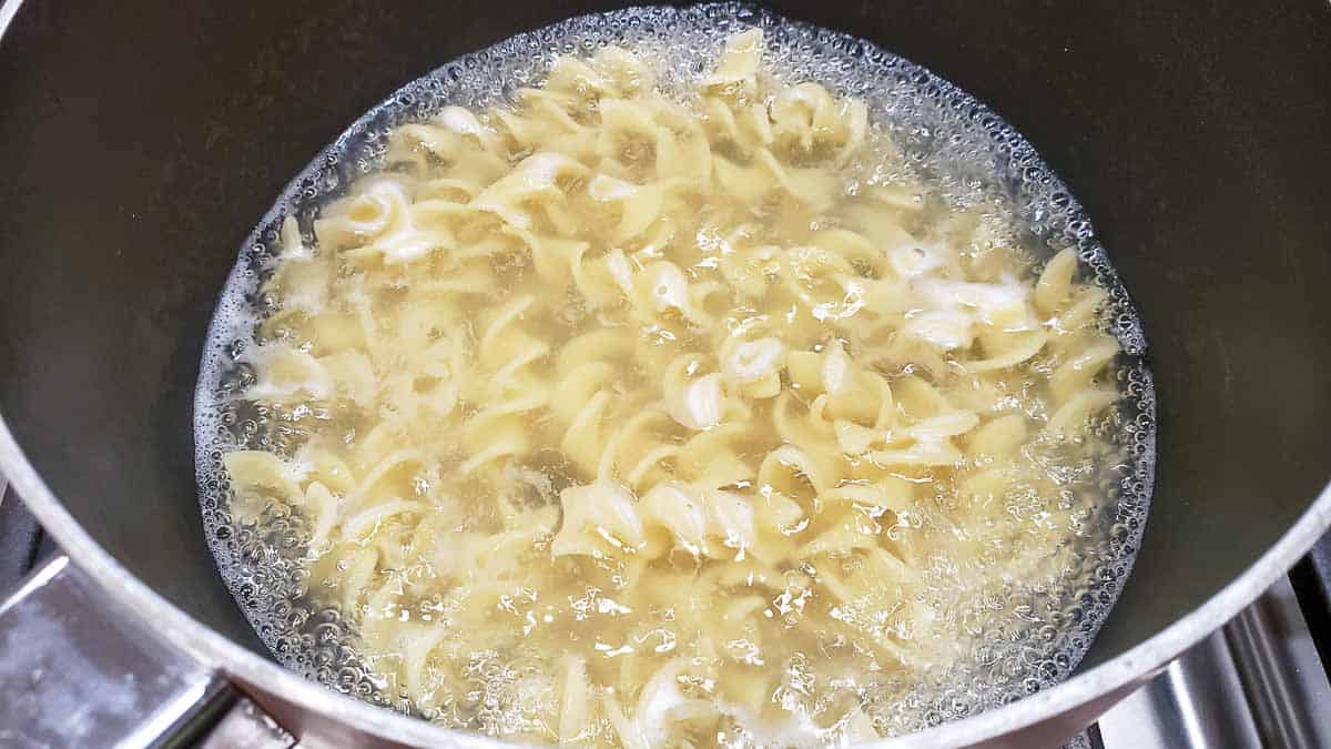 egg noodles boiling in a pan.