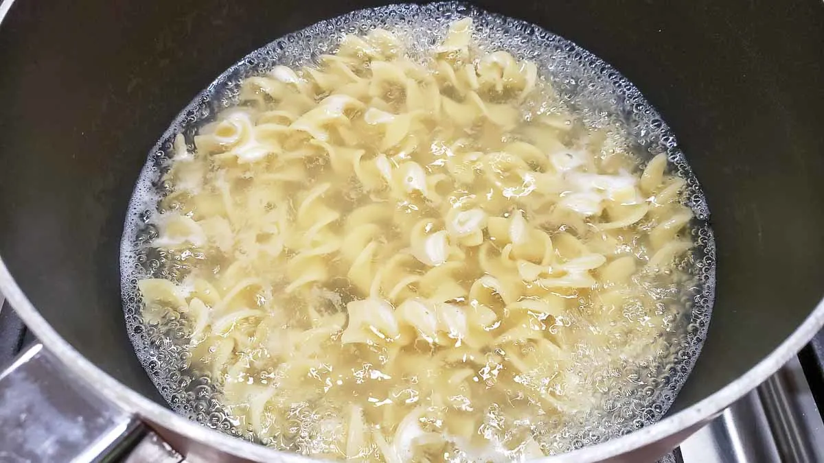 egg noodles boiling in a pan.