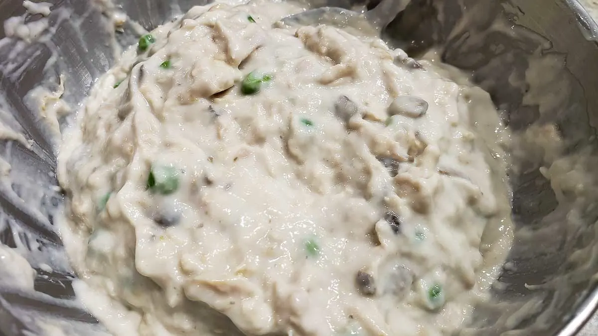 mushroom soup mixed with tuna and peas in a bowl.