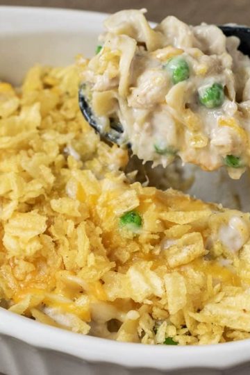 tuna noodle casserole in a baking dish with a spoon lifting out some casserole