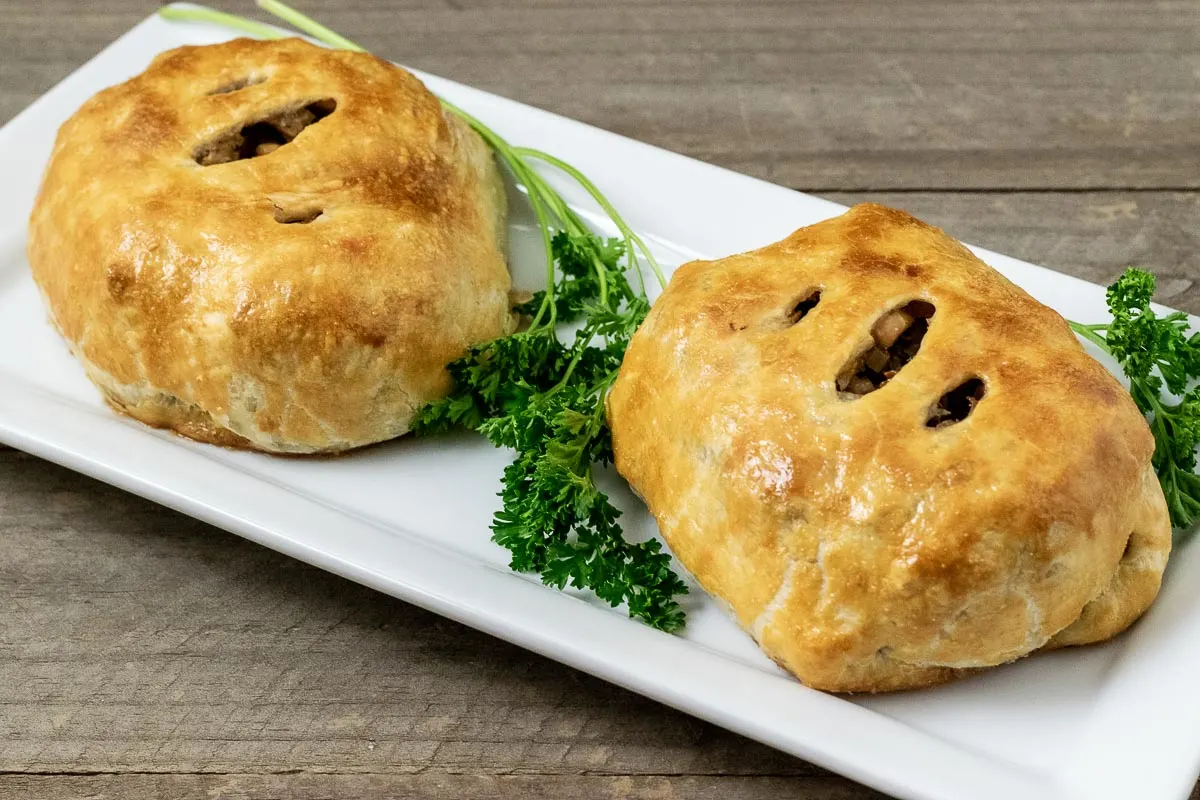two easy individual beef wellingtons on a platter with parsley.
