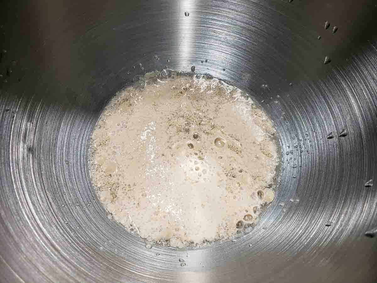 yeast, sugar, and warm water activating in a bowl.