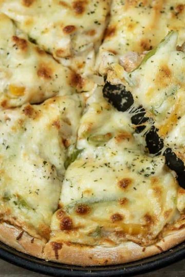 top down view of Chicken Fajita Pizza with slice lifting out of pn