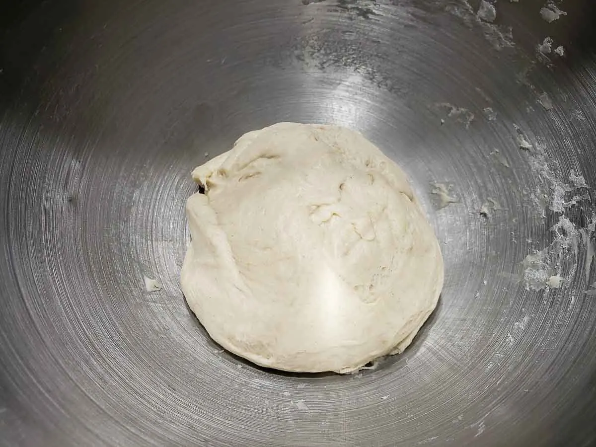 soft pizza dough in a silver bowl.