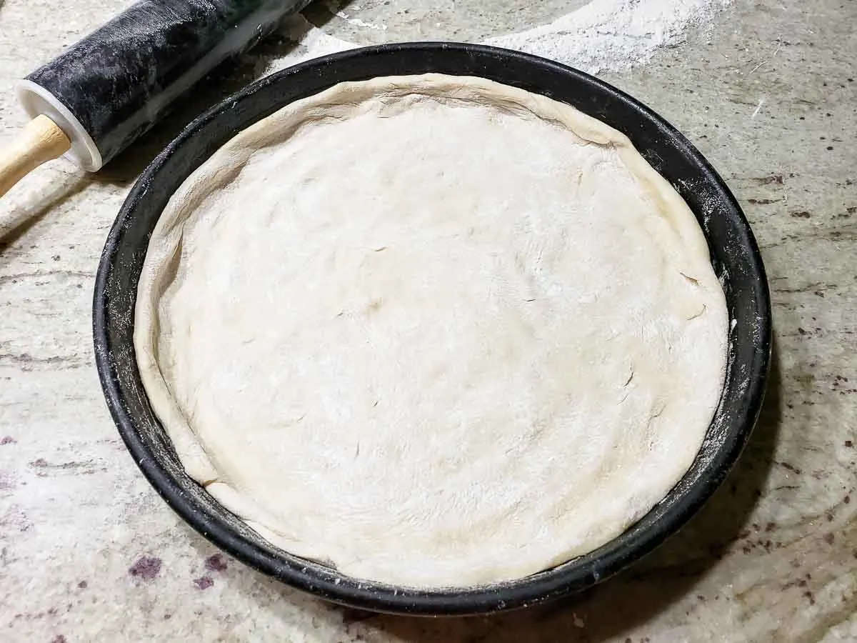 12" pizza dough placed in a pizza pan.