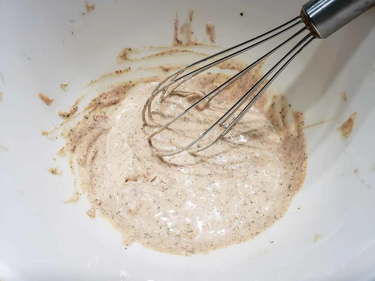 fajita sauce mixed in a bowl with a whisk.