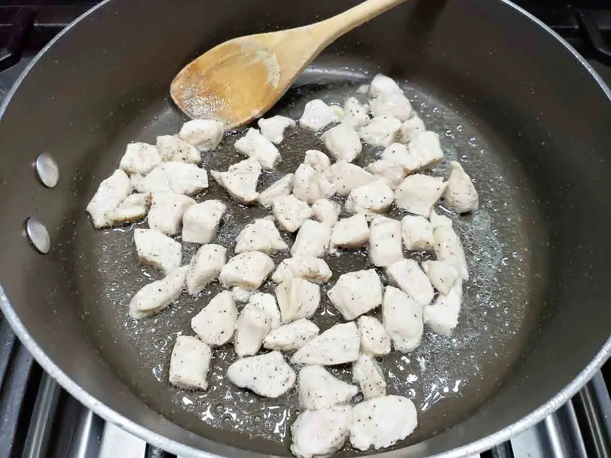 diced chicken cooking in a pan.