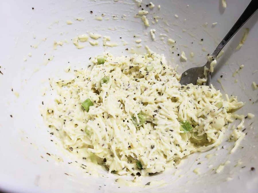 イタリアの細切りチーズ、サワークリーム、ネギ、卵、バジル、塩、コショウをボウルに混ぜたもの