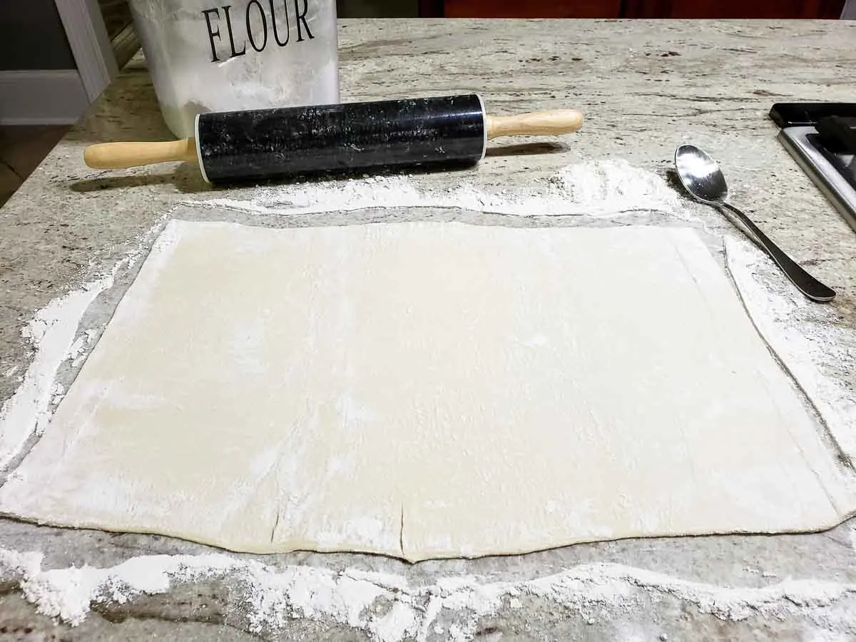 a sheet of puff pastry rolled out on a counter.