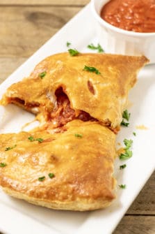 Puff Pastry Pizza Calzone on a tray with a side of pizza sauce.