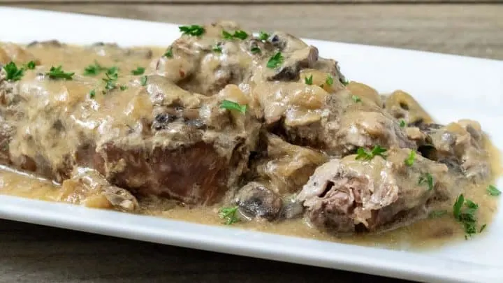 close up front view of Slow Cooker Country Style Pork Ribs and Mushroom Gravy on a platter