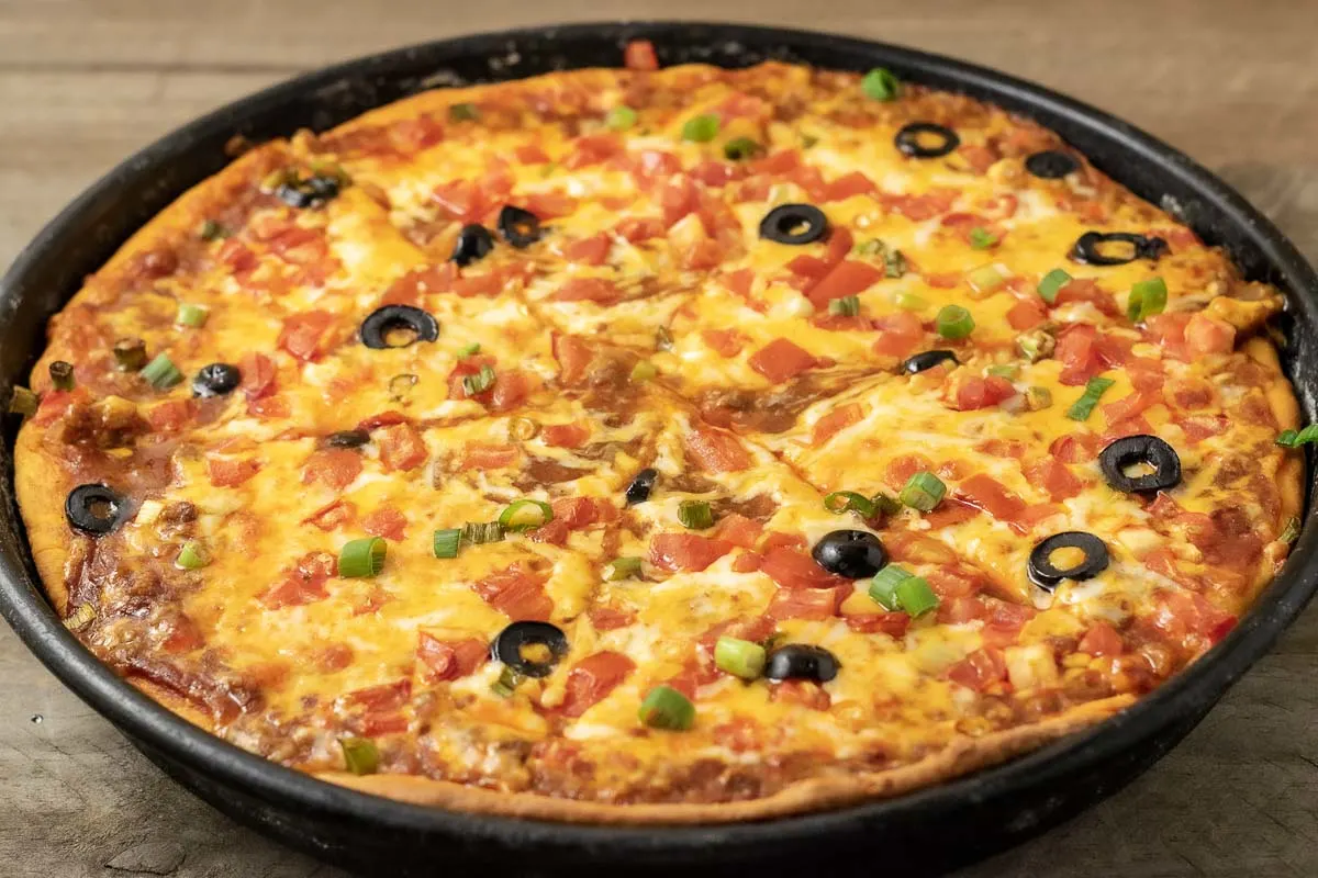 front view of enchilada pizza pie in a pizza pan.