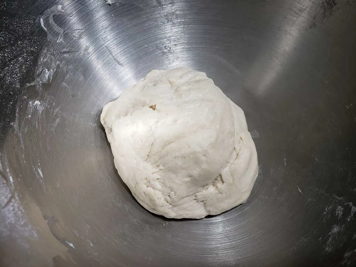 pizza dough formed into a ball in a bowl.