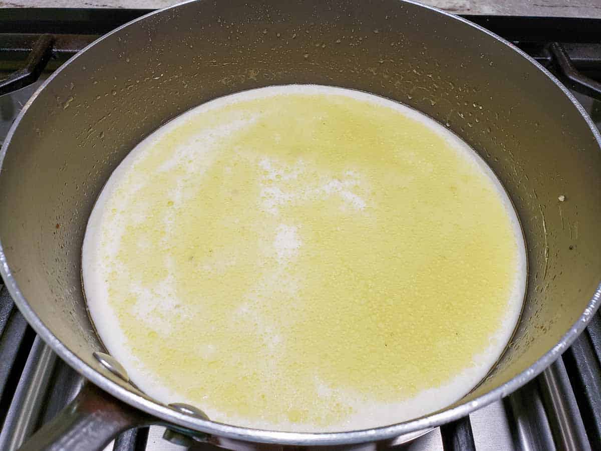 heavy cream added to sauce cooking in a pan.