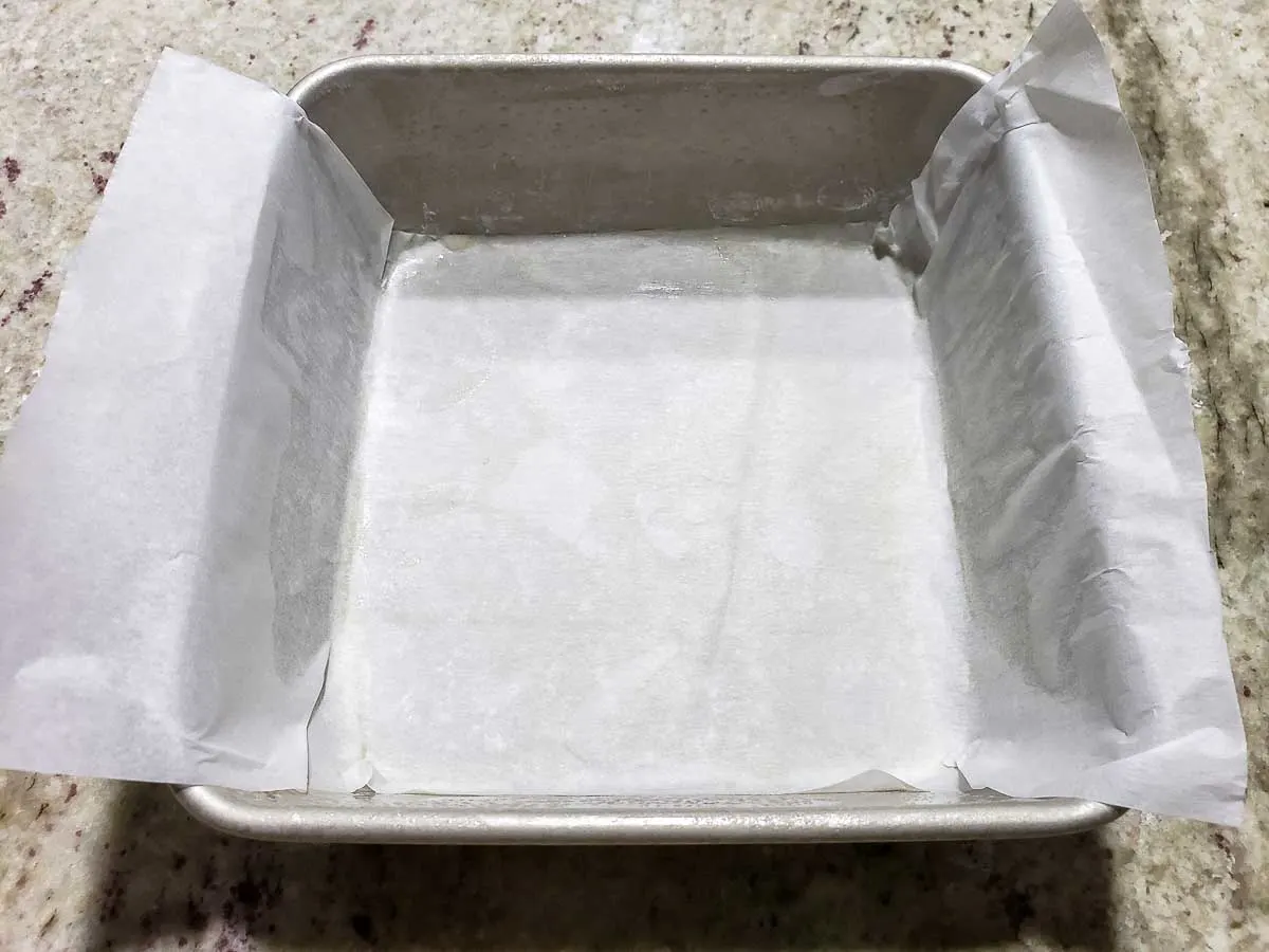 a parchment paper sling placed in a cake pan.