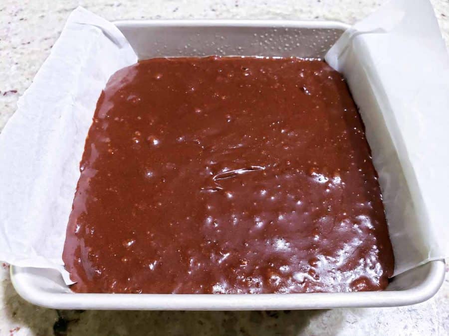 fudgy brownie batter in a cake pan