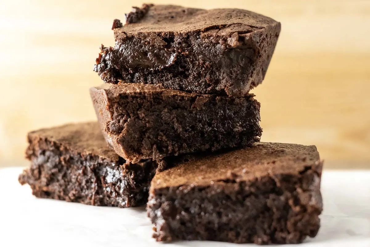 4 chewy Fudgiest Brownies Ever stacked in a pile.