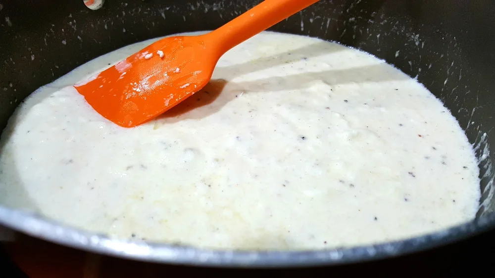 alfredo sauce cooking in a pan