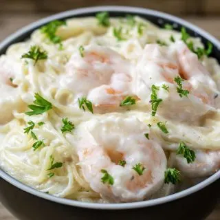 a close up front view of shrimp alfredo in a bowl