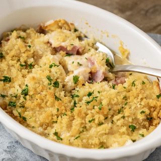 a close up front view of Low-carb Chicken Cordon Bleu Casserole with a spoon digging into the casserole