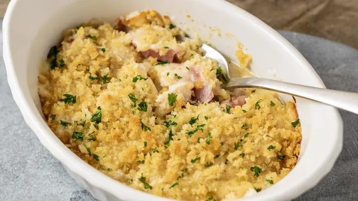 a close up front view of Low-carb Chicken Cordon Bleu Casserole with a spoon digging into the casserole