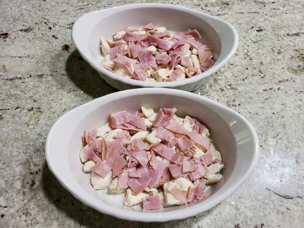 chopped ham lunchmeat layered over chicken in two dishes.