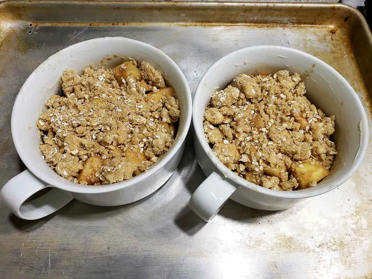 Apple Crumble in two dishes on a baking sheet.