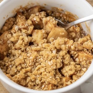 easy Salted Caramel Apple Crisp in a baking dish with a spoon