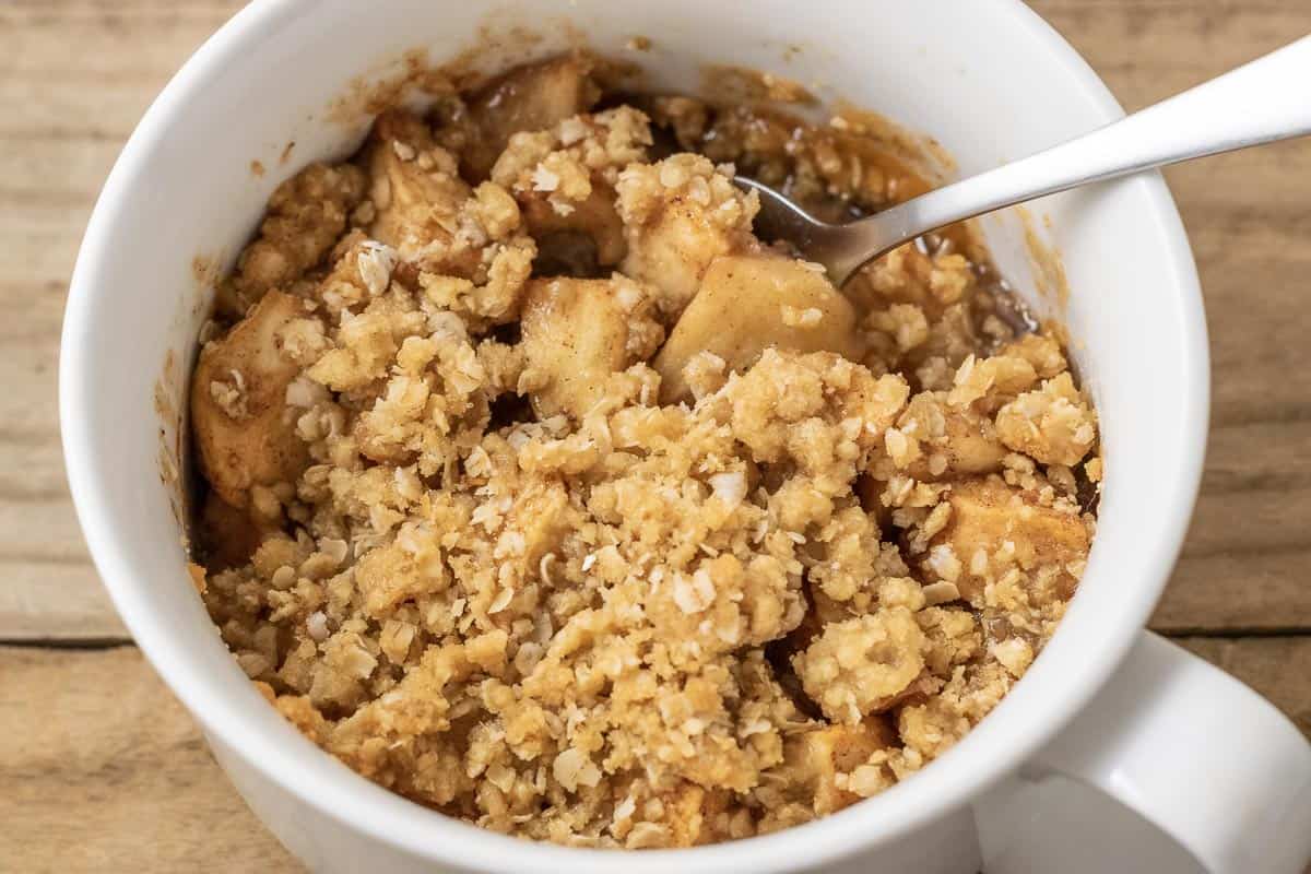 easy Salted Caramel Apple Crisp in a baking dish with a spoon.