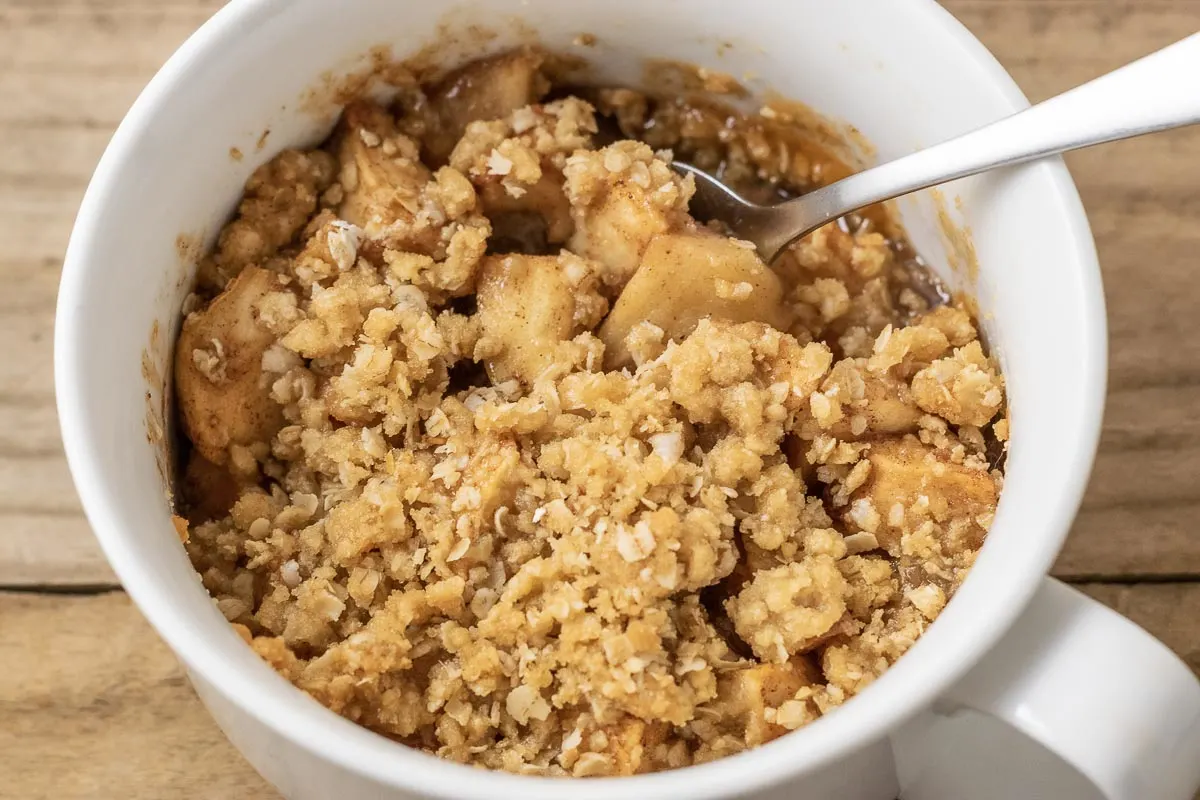 easy Salted Caramel Apple Crisp in a baking dish with a spoon