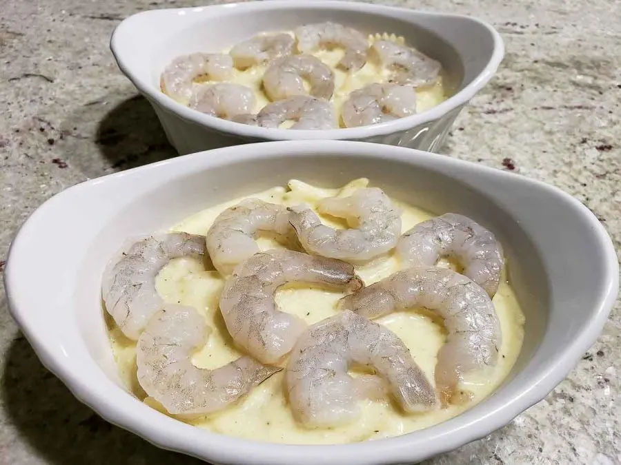 raw shrimp layered over pasta mixture in two dishes