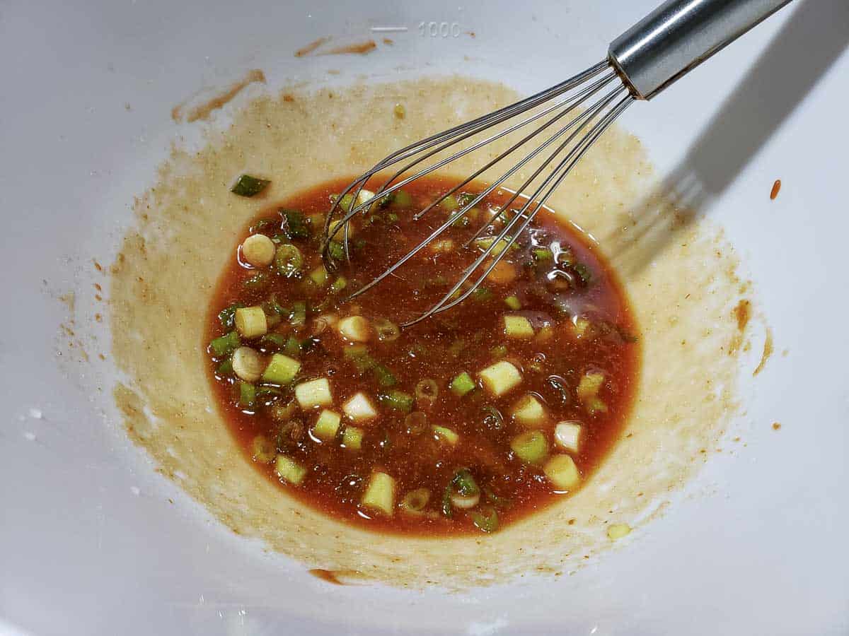 Sauce in a bowl with a whisk.