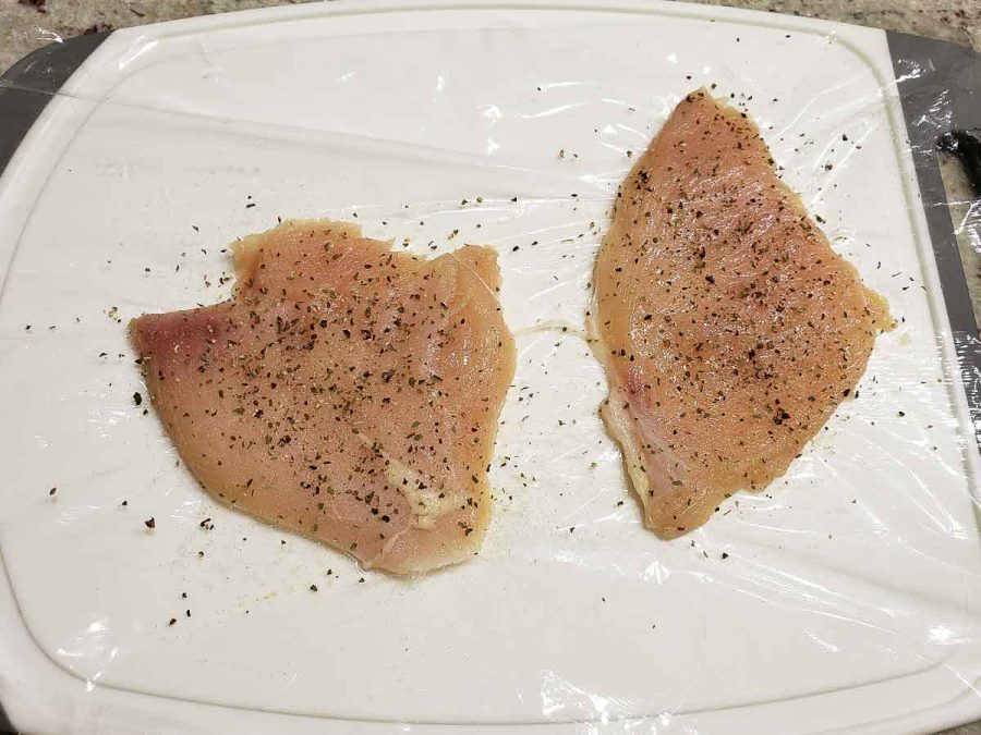 two chicken cutlets pounded flat and sprinkled with seasonings