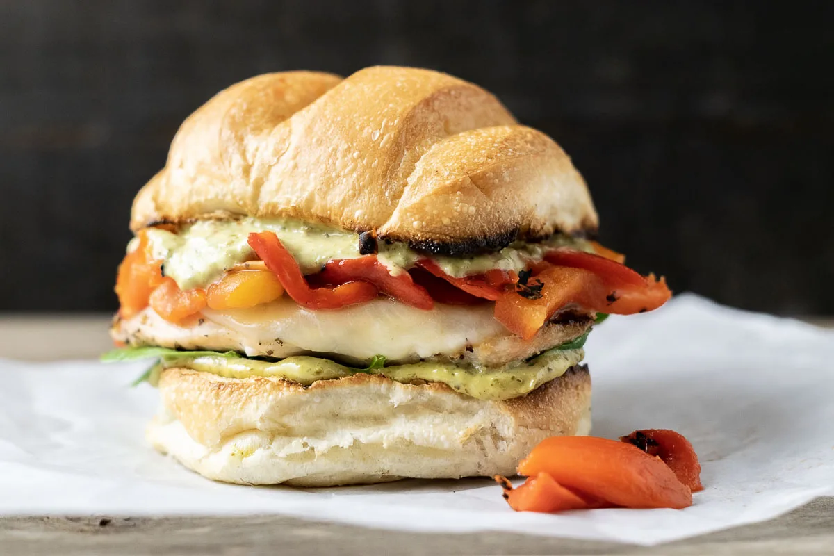 a Tuscan Chicken Sandwich on parchment paper.