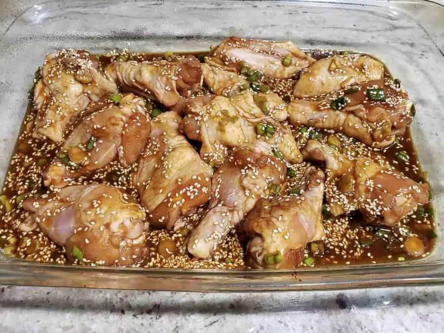 Asian sticky chicken wings in a 9 x 13 dish ready to bake.