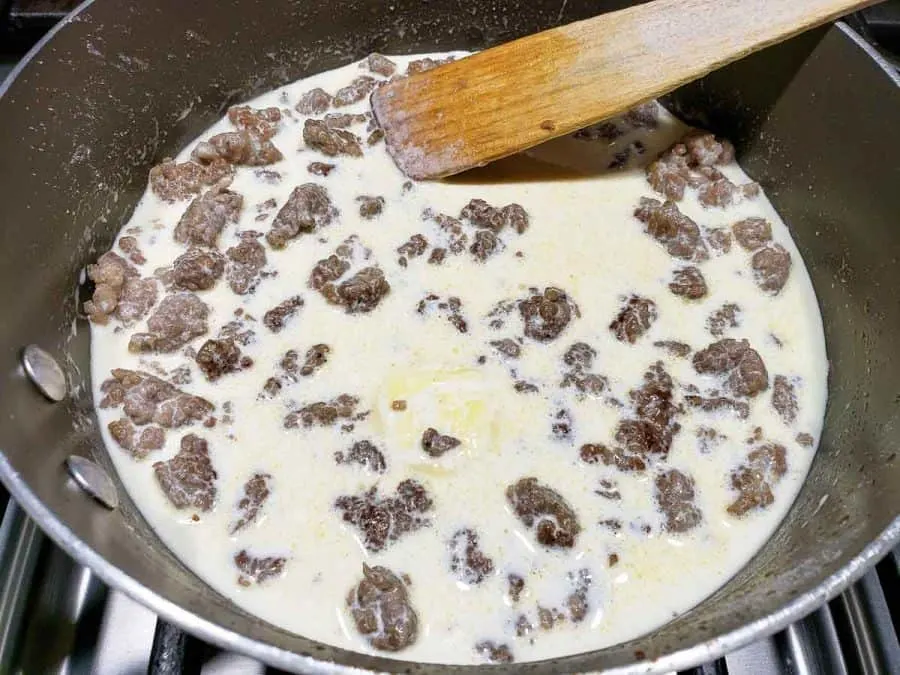 easy sausage gravy being thickened in a pan