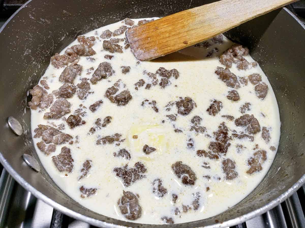 easy sausage gravy being thickened in a pan