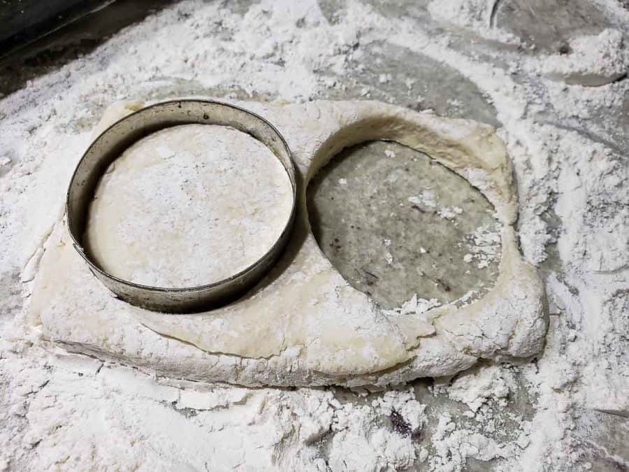 a 3" circle cutter cutting two homemade biscuits