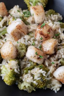 close up view of Scallops with Rice and Broccoli with parmesan cheese and brown butter drizzle on a plate