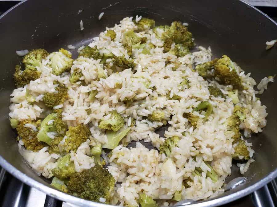 parmesan rice and broccoli cooking in a pan