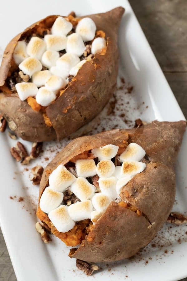 two sweet potatoes with marshmallow, brown sugar, butter, and pecan stuffing.