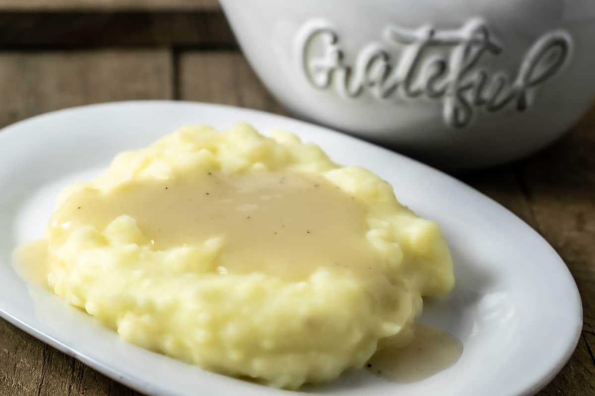 easy chicken gravy from scratch poured over mashed potatoes on a plate