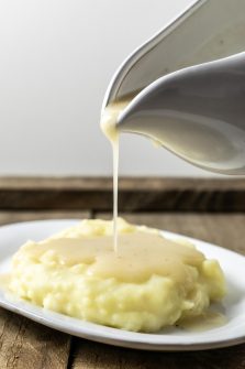 easy 5 ingredient chicken gravy being poured over mashed potatoes