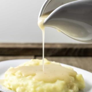 easy 5 ingredient chicken gravy being poured over mashed potatoes