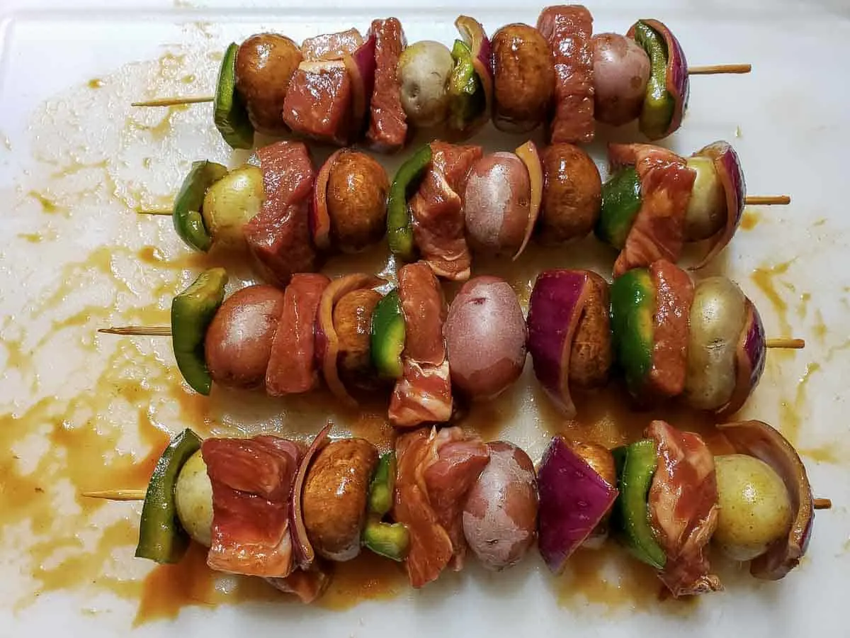 four marinated steak kabobs assembled on skewers