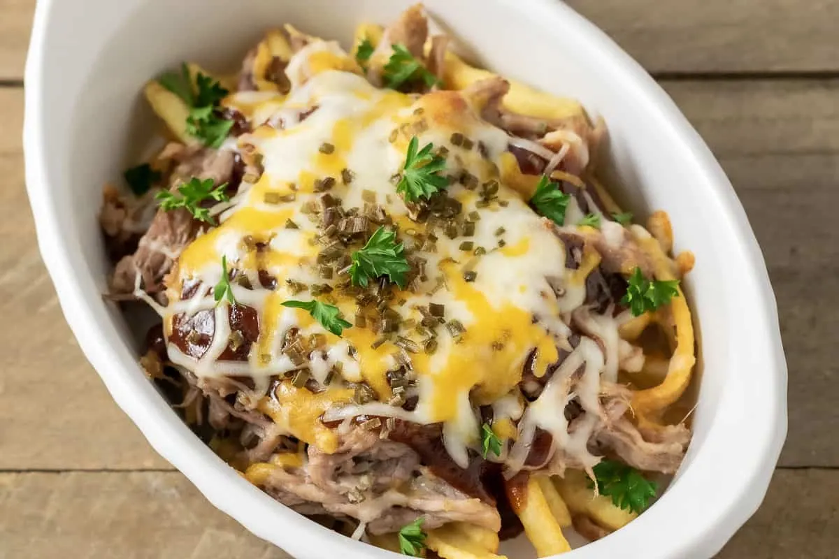 a baking dish filled with pulled pork loaded fries