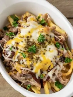 a close up top down view of Cheesy BBQ Pulled Pork Fries in a baking dish