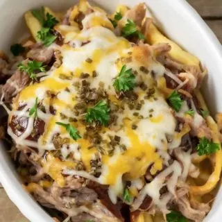 a close up top down view of Cheesy BBQ Pulled Pork Fries in a baking dish